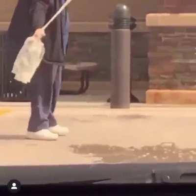 Guy breaks a bag full of urine in a parking lot