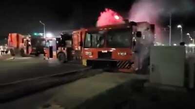 Rioters in Kenosha, Wisconsin breaking the windows of several dumptrucks before setting them on fire