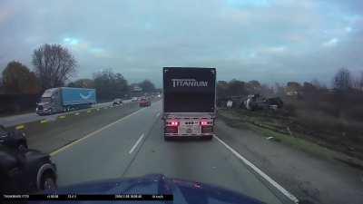Truck hauling steel coil rolls over