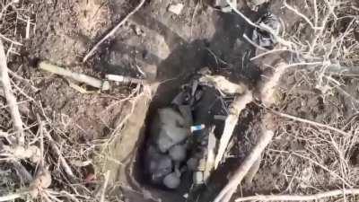 Russian soldier hiding in a foxhole tries to sit perfectly still to remain unseen - The Ukrainian drone drops a grenade on him anyway