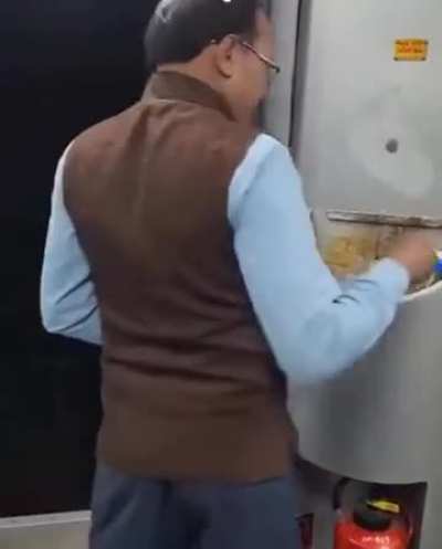 Train staff casually disposing trash right outside a running train