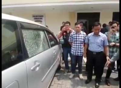 A robber caught by police and demonstrating how he breaks the car window glass using spit and salt