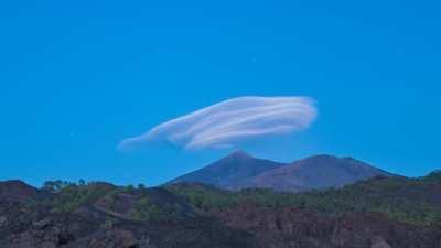 Flying saucer shaped lenticular clouds changing colors.