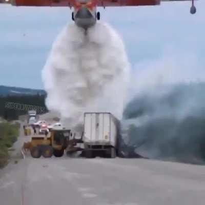 Water bomber coming in close to put out a fire.