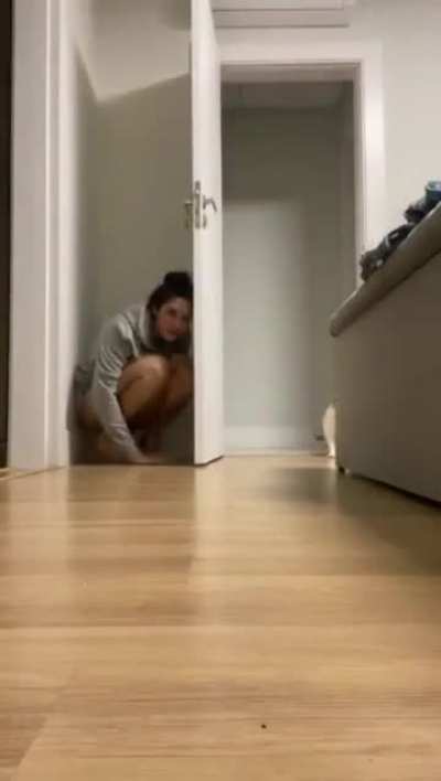 Girl tries to hide from cat