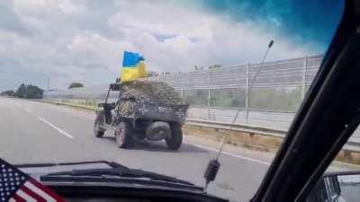An old open-air antique Jeep a bomber hat and goggles and a smooth highway in Ukraine, every man's dream.  The Ukrainians can deliver aid and equipment to any war zone (Rostov too) but what exactly is that thing? 