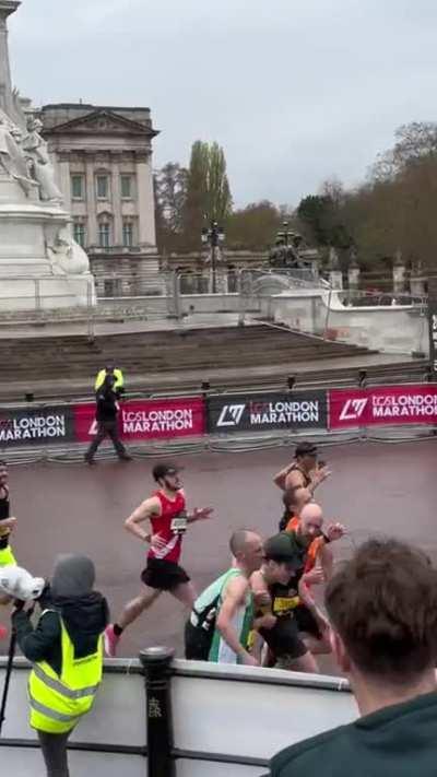 Marathoners help a fellow runner to the finish line (London)