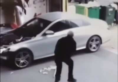 The car rolls over the mop, and the handle strikes him in the face.. twice