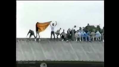 1980s English football hooligan climbs onto roof of stand