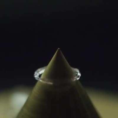 Drop of water falling on a sharp point