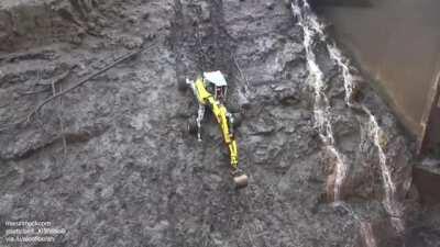Walking excavator crawls to the bottom of a reservoir to clear the blockage