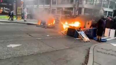Seattle black bloc anarchists set up a flaming roadblock as they wait for police to show up