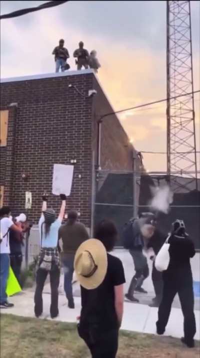 Masked ICE sniper shoots priest in the eye with a pepper ball while he is pleading with them at a protest near Chicago.