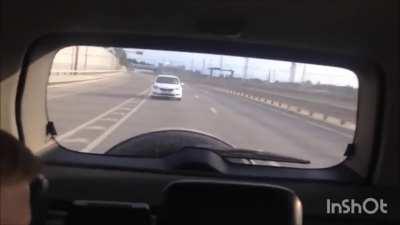 A guy using phone on the highway, going slow, gets honked at. He flips at 'em and wins the prize.