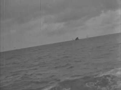 10.5cm deck gun on a Kriegsmarine Type IX U-Boat scores a direct hit on the stern of a sinking merchantman in the Southern Atlantic in early 1941