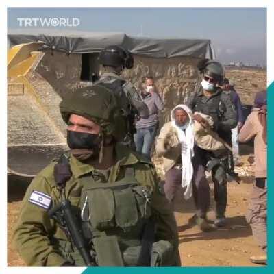 Elderly Palestinian man stands in front of a bulldozer to stop Israeli soldiers from demolishing homes in the southern occupied West Bank.