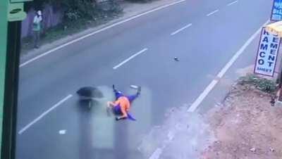 Woman opens up an umbrella while traveling on the back of a motorcycle