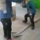 Two kids playing with a shovel