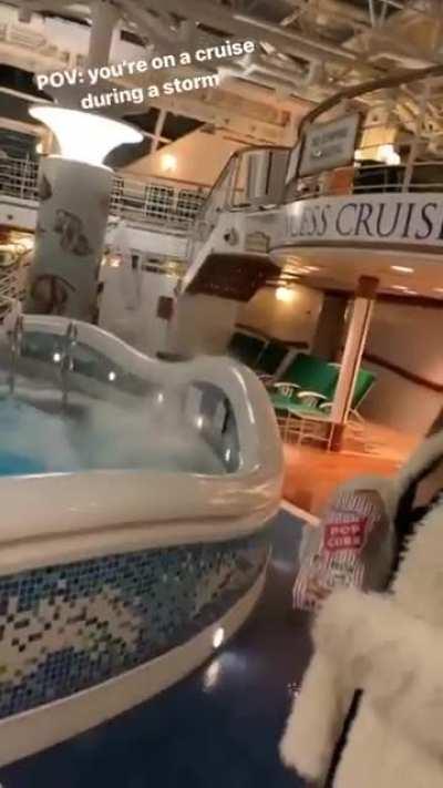 Guests sitting at the pool on a cruise during a storm