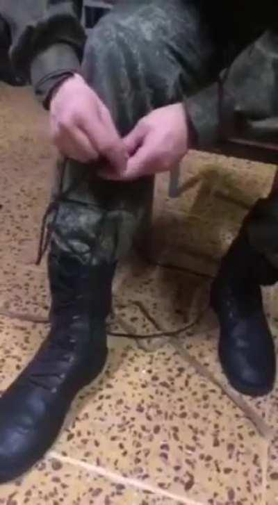 Fresh mobilized Russian soldier struggles to tie his shoelaces