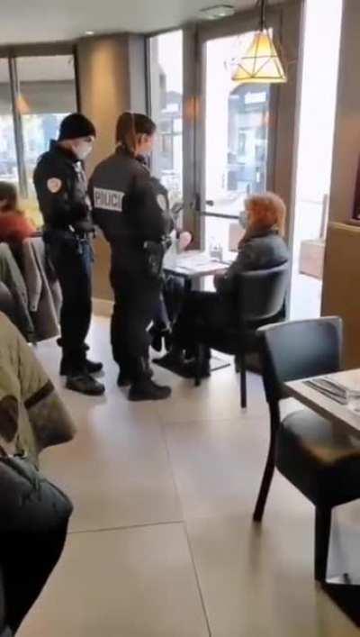 French police going table to table checking vaccine passports, ID, and medical history.