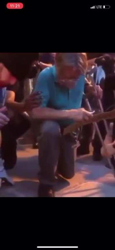 This old man kneeling during this protest