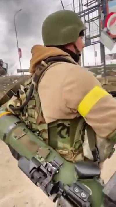 Just a Ukrainian soldier casually walking past a destroyed column