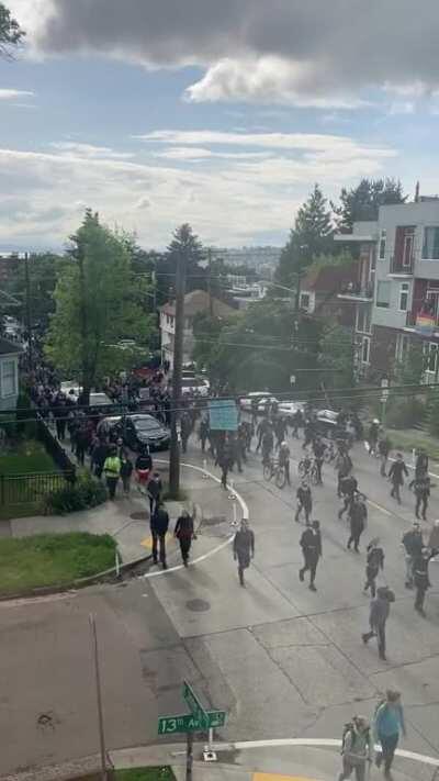 Protest moving up E John Street. Cops following behind.