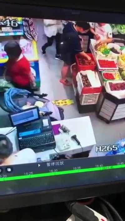 Middle-aged woman pinches off a small piece of flesh from a baby as she leaves the supermarket