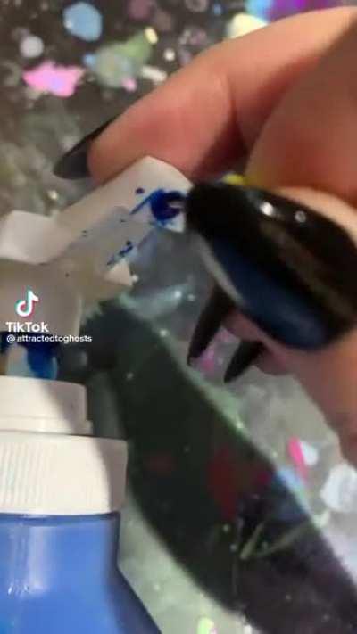 Dried paint being pulled out of a bottle top