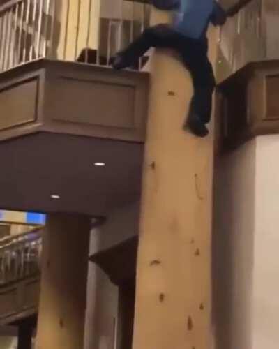 Guy tries to slide down this support beam and fails miserably