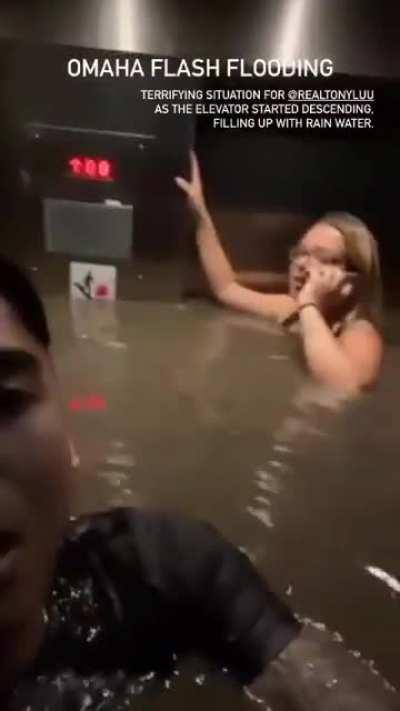 People in Omaha trapped in an elevator with neck-deep water descending into a flooded basement, after a flash flood (08/08/2021)