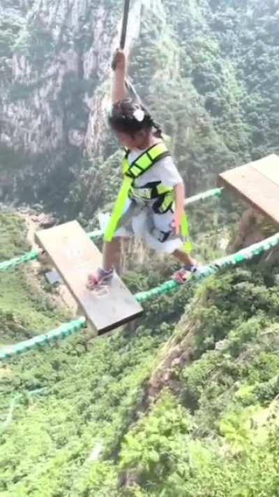 Kid walking over a dangerous high bridge