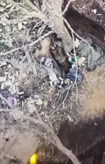 Russian soldier crawls into a hole where a drone dropped grenade just landed