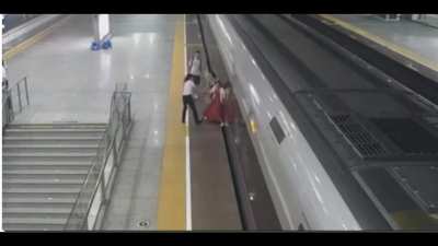 Chinese woman arrived late to the train so staff refused to accept her ticket. She then jumped the gates and tried to stop the train from departing the station by sticking her foot in the gap.
