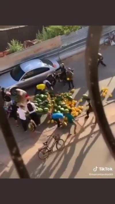 People in Morocco helping fruits Street vendor after his merchandise fell off.