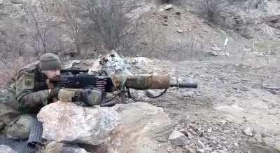 Maxim with a suppressor, scope, stock, biopod and camo.