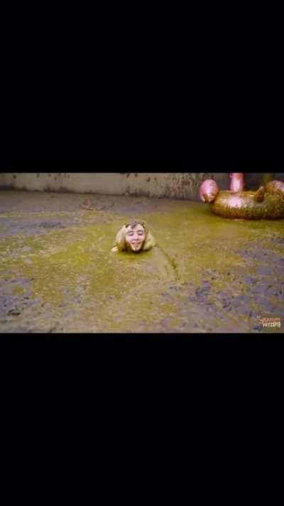 German girl swims in a pool of elephant shit