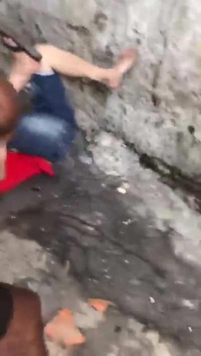 This guy in red shirt being beaten for unknown reason in a 