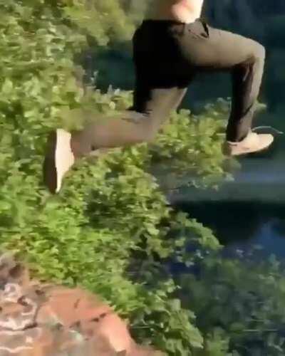 Guy jumps off cliff into the dam after a few drinks