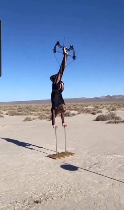 Acrobat doing foot archery.