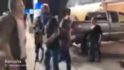 Crowd gets angry after gas station defenders extinguish a dumpster fire