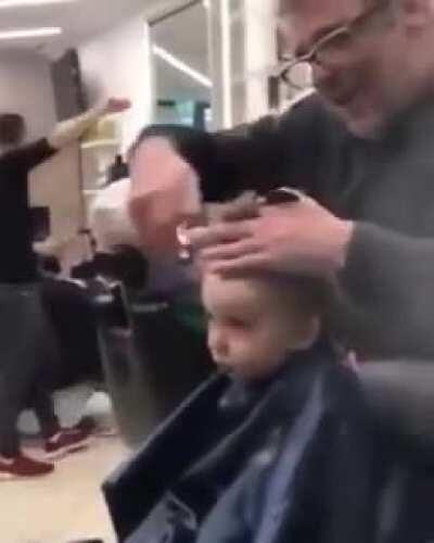 Bunch of dudes singing to help stop baby boy from crying during his haircut