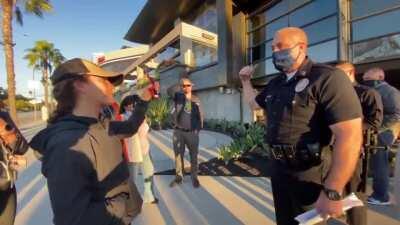 Cop is being really patient explaining to Karen why she can't go into the mall without her mask.