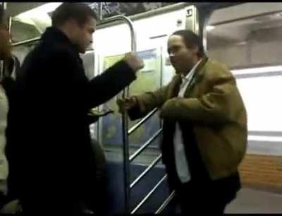 Snackman breaks up fight by putting up hand up and inserting himself between the two and continues eating chips.