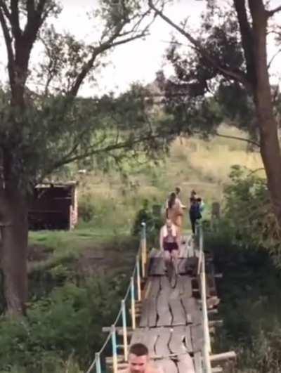Crossing this rickety bridge on a bike