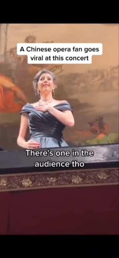 An audience member joins in at the male tenor part of an opera concert