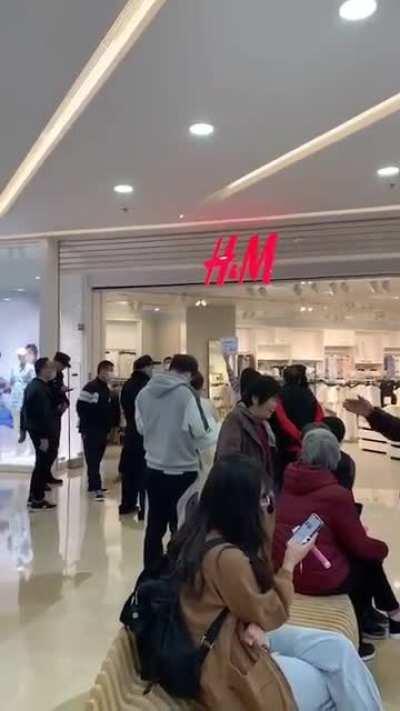 一位耶格尔派的兔友正在万达里面举牌。 旁边的晶哥好像是在劝她😂