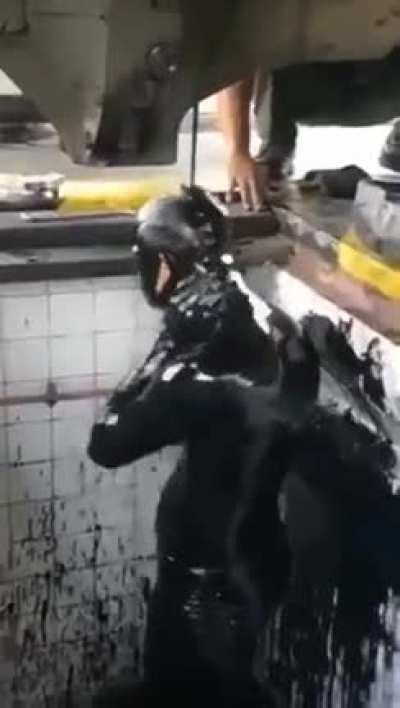 Man washing himself with car fluids