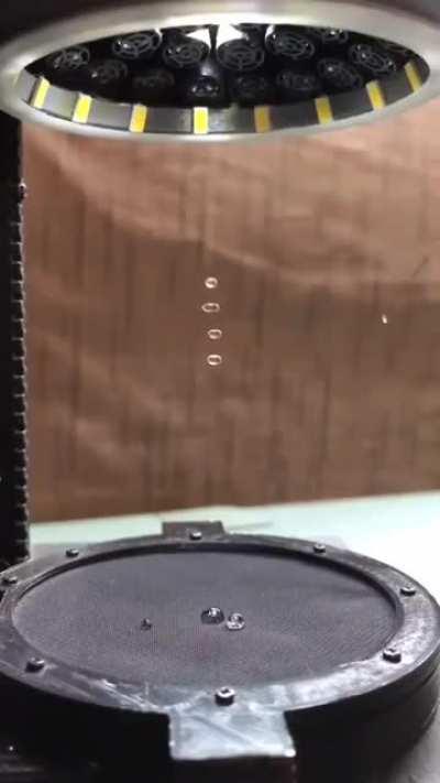 Gotículas de água sendo suspensas no ar pelo processo de levitação acústica. Utilizando a frequência correta, as ondas sonoras podem fazer pressão o suficiente para manter as gotas de água paradas na mesma posição.